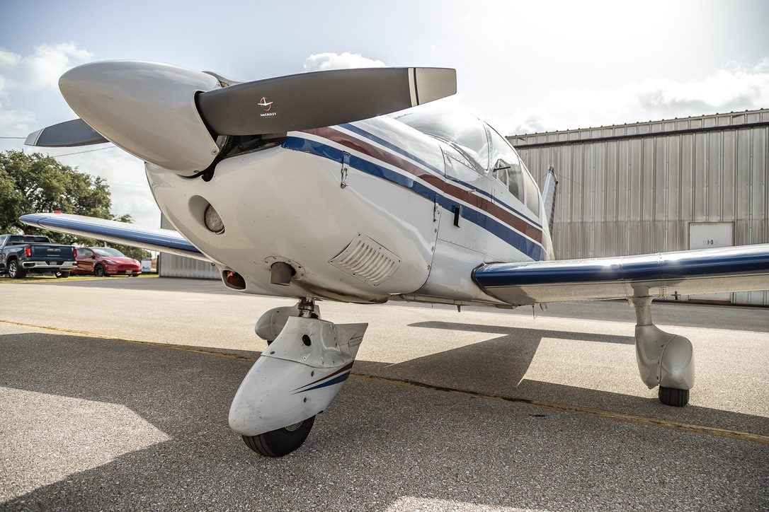 Low-angle nose and propeller detail of N8513W by the hangar